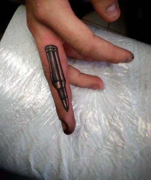 Tatuagem de uma bala no dedo do cara