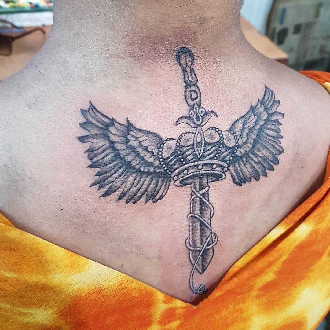 Tatuagem de uma espada nas costas da mulher