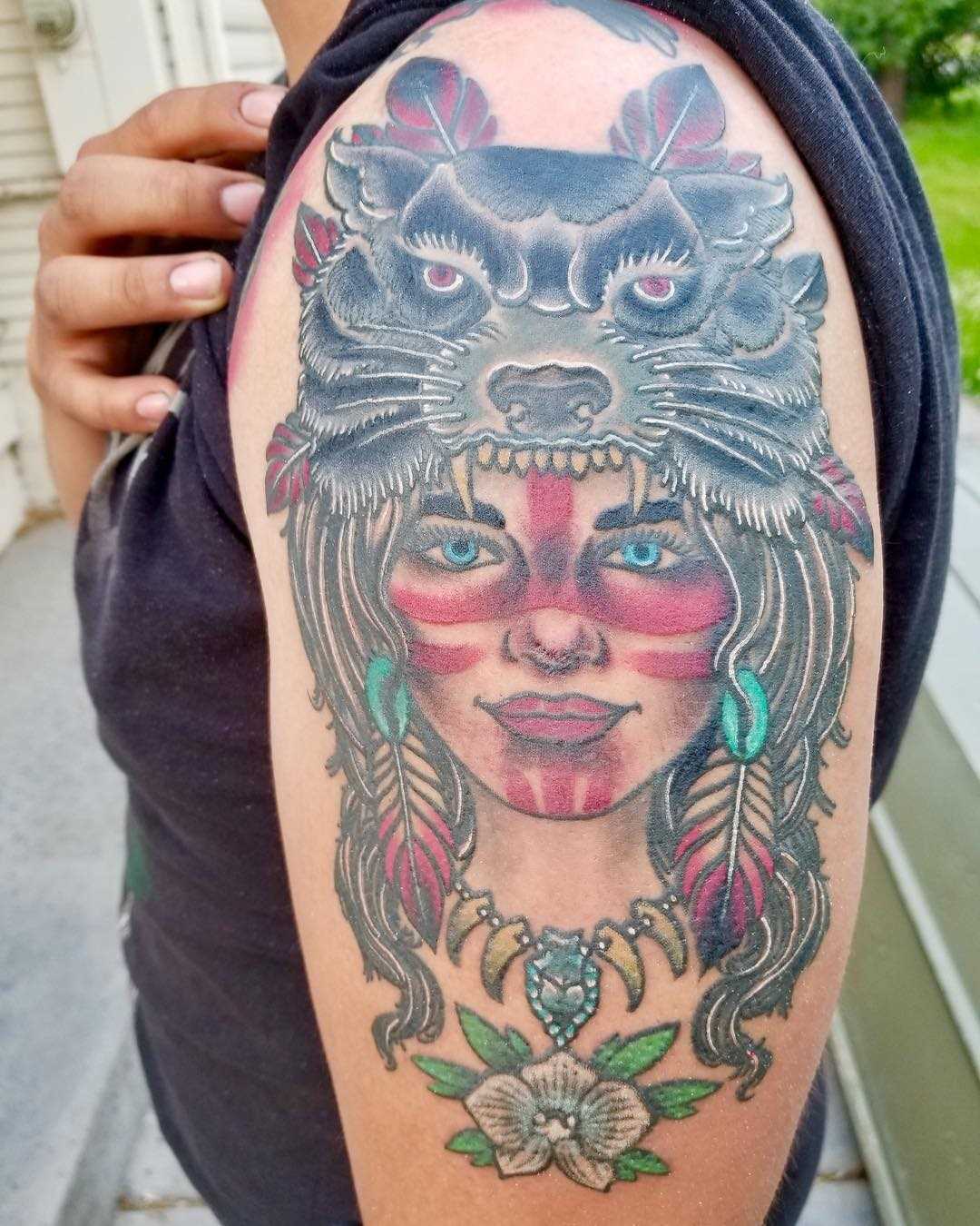 Tatuagem de uma menina indígena com o lobo no ombro da mulher