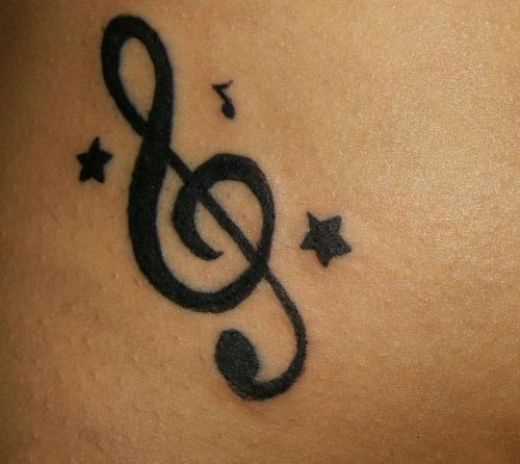 Tatuagem na barriga da menina - clave de sol, as estrelas e nota