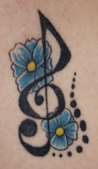 Tatuagem na barriga da menina - clave de sol e de flores