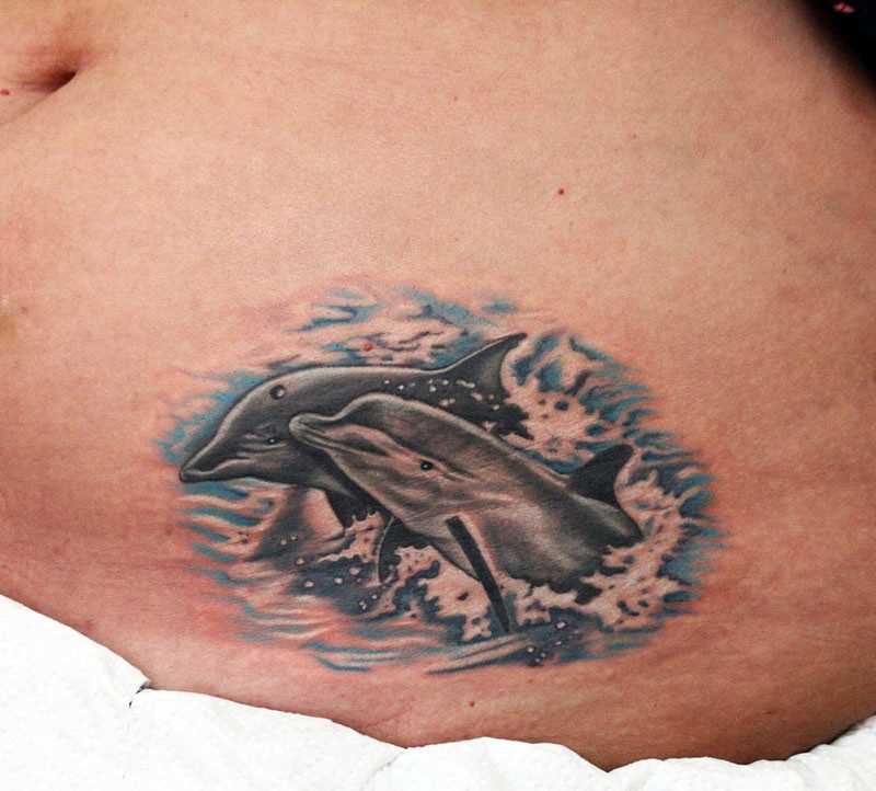Tatuagem na barriga da menina - golfinhos