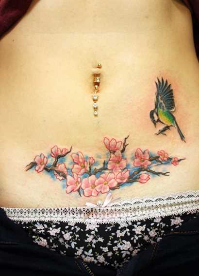 Tatuagem na barriga da menina - sakura e o beija-flor