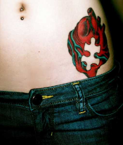 Tatuagem na barriga de uma menina de quebra - cabeça no coração