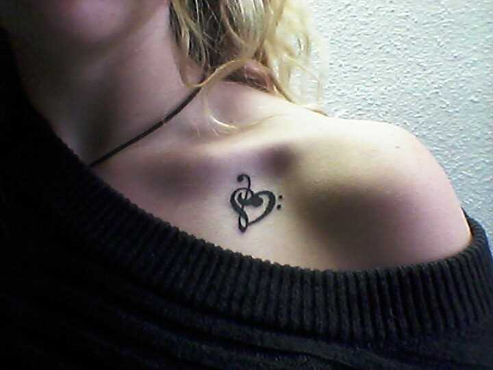 Tatuagem na clavícula uma menina - a clave de sol e o coração