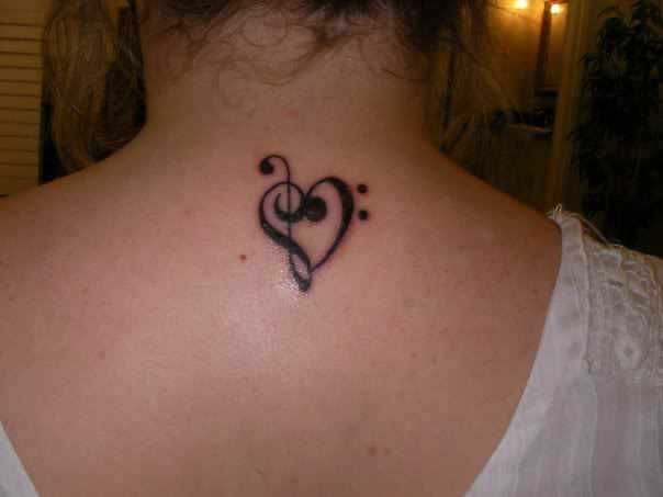 Tatuagem na coluna da menina - clave de sol e o coração
