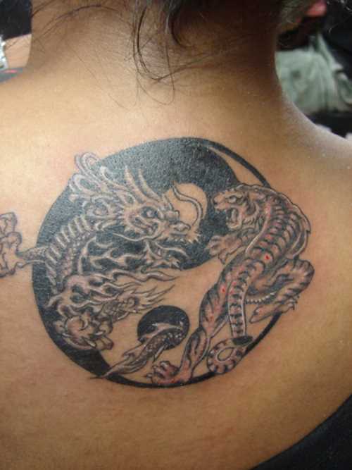 Tatuagem na coluna da menina - o dragão e o tigre como símbolo do Yin-Yang