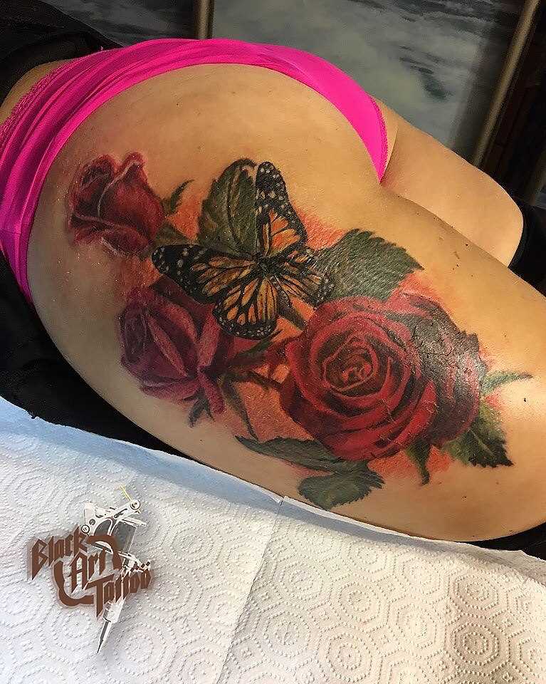 Tatuagem na coxa da menina - borboleta e a rosa