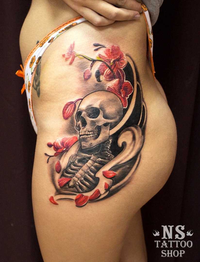 Tatuagem na coxa da menina de crânio com flores