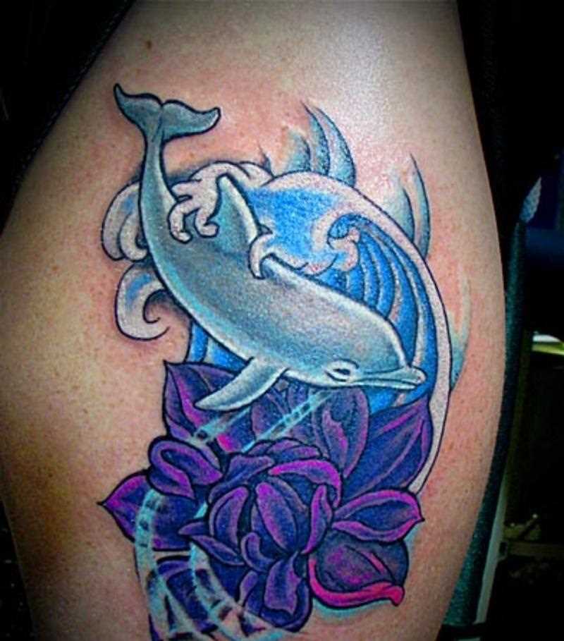Tatuagem na coxa da menina - o golfinho e a flor