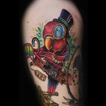 Tatuagem na coxa da menina - papagaio no cilindro e com monoklem