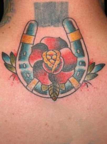 Tatuagem na espinha cara - de- ferradura e a flor