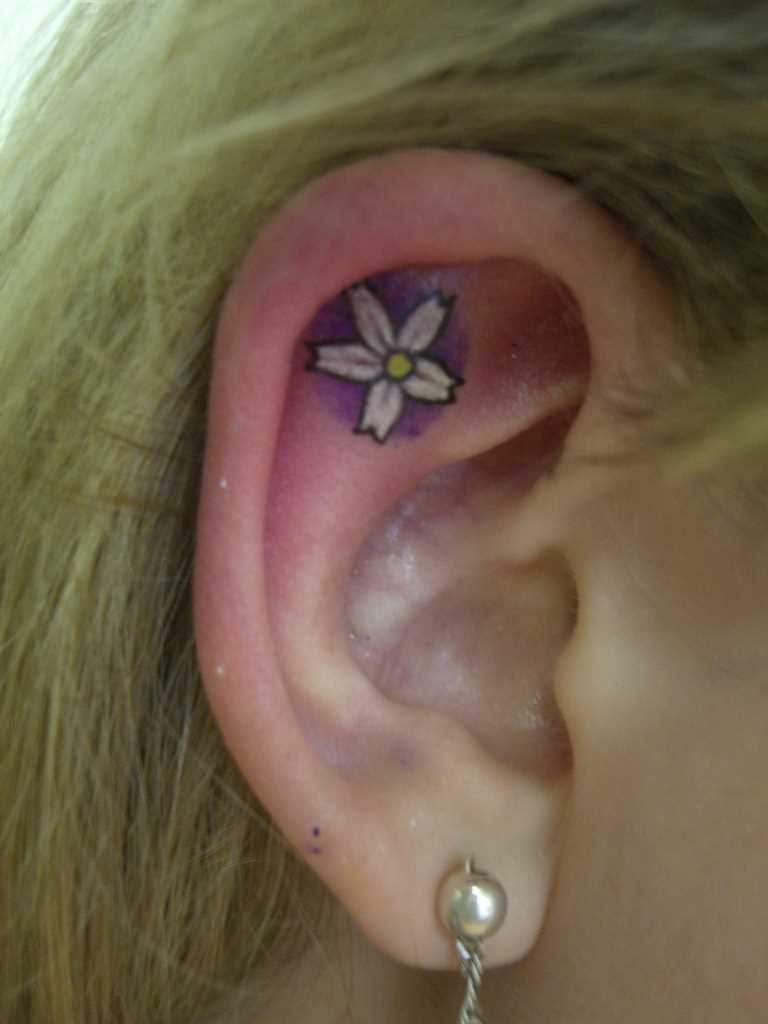 Tatuagem na orelha da menina - flor