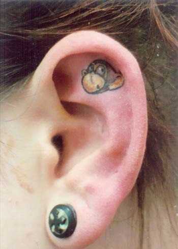 Tatuagem na orelha da menina - macaco