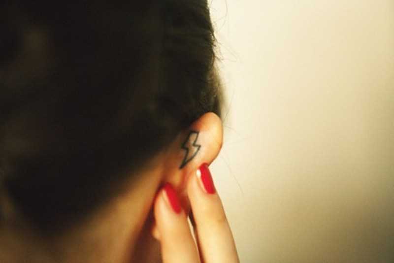 Tatuagem na orelha da menina - relâmpago