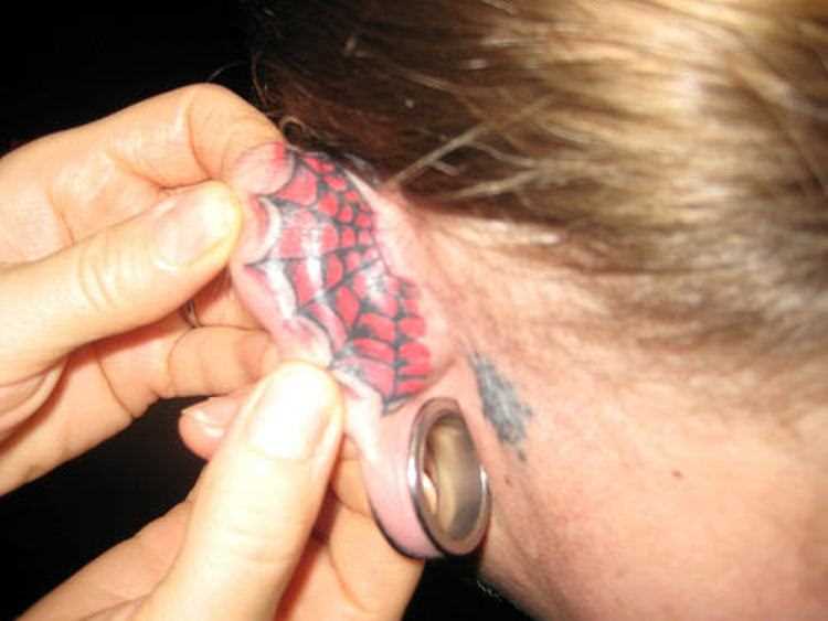 Tatuagem na orelha da menina - teia de aranha