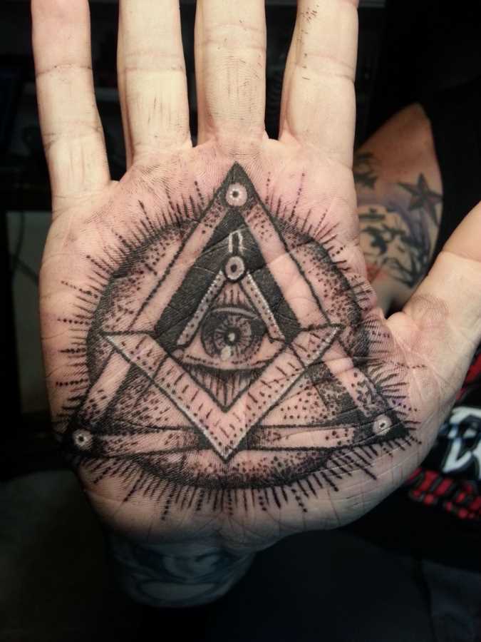 Tatuagem na palma da mão da menina - a pirâmide com o olho