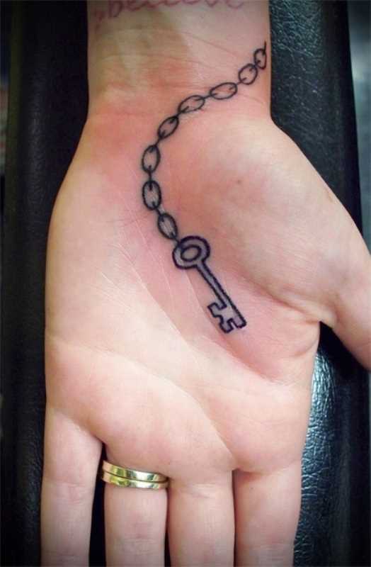 Tatuagem na palma da mão da menina - corrente com a chave