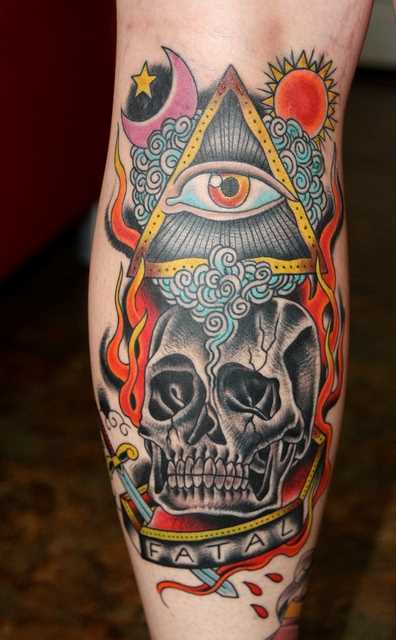 Tatuagem na perna da menina - a pirâmide com o olho, o crânio, a lua e o sol