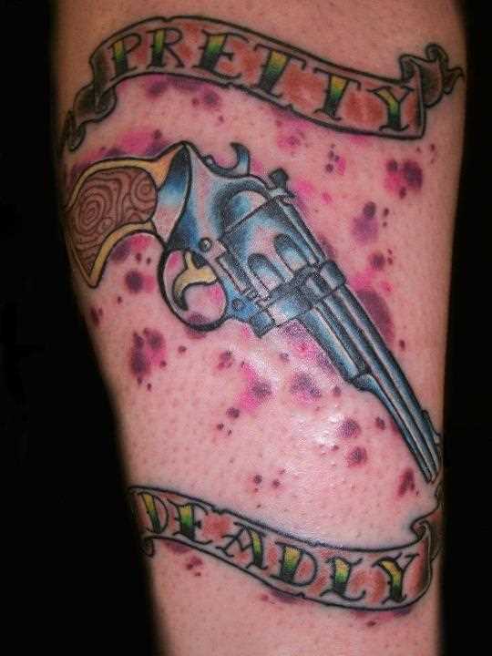 Tatuagem na perna da menina - arma e inscrição