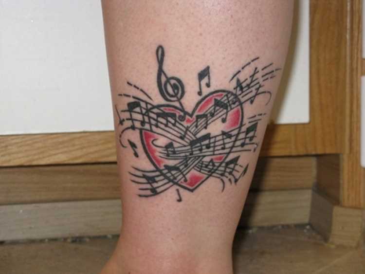 Tatuagem na perna da menina - as notas da clave de sol e o coração