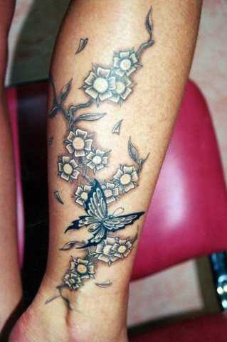 Tatuagem na perna da menina - borboleta e flores