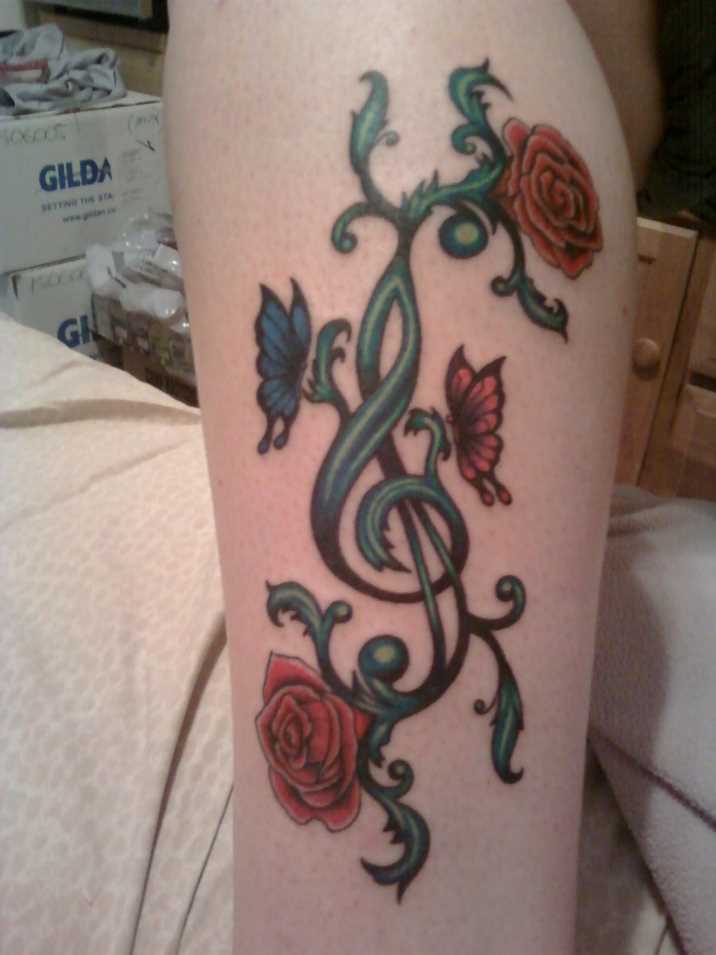 Tatuagem na perna da menina - clave de sol, a rosa e a borboleta