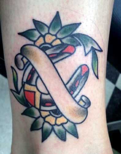 Tatuagem na perna da menina - ferradura e flores