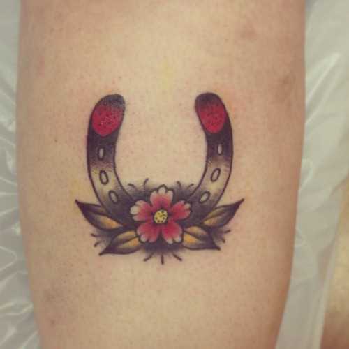 Tatuagem na perna da menina - ferradura e florzinha