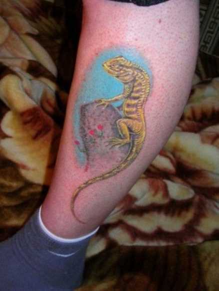 Tatuagem na perna da menina - lagarto em pedra