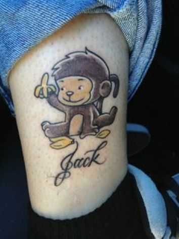 Tatuagem na perna da menina - macaco com uma banana e inscrição