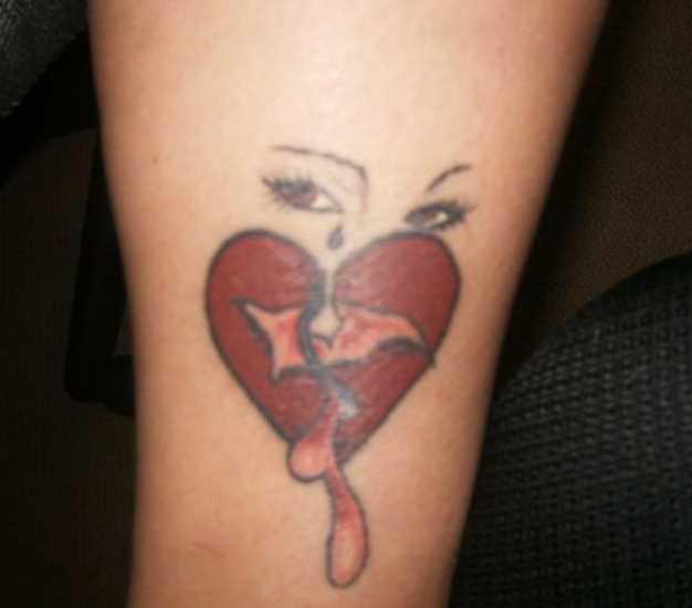 Tatuagem na perna da menina - o coração e o rosto de uma menina
