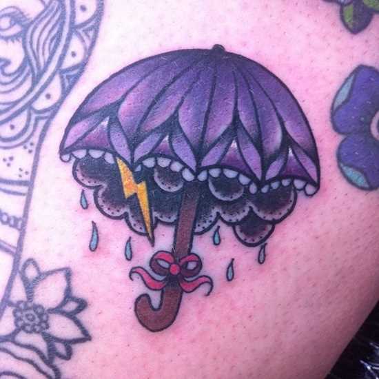 Tatuagem na perna da menina - relâmpago, chuva e um guarda-chuva