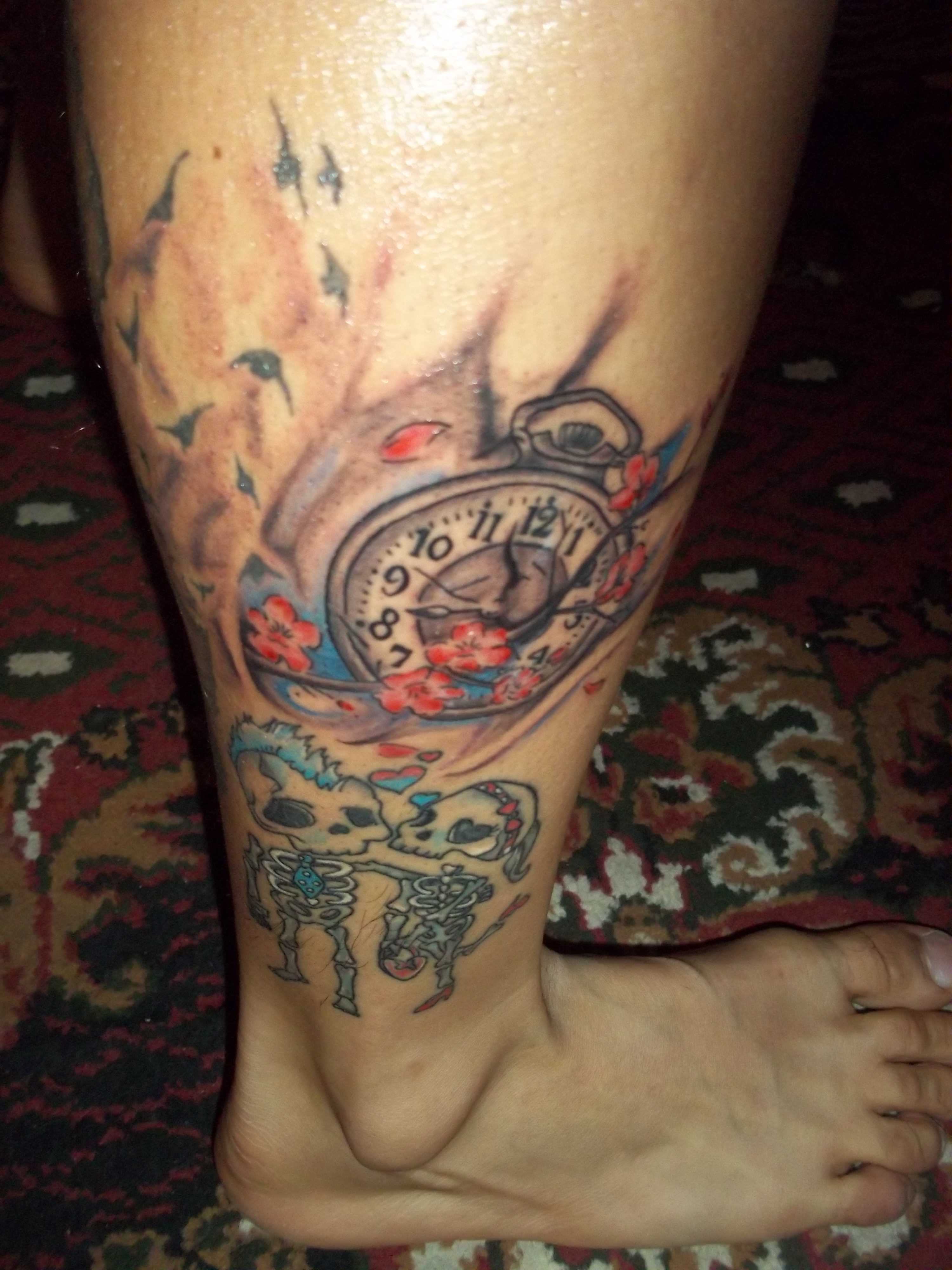 Tatuagem na perna da menina - relógio de bolso e esqueletos