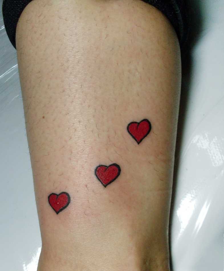 Tatuagem na perna da menina - três corações