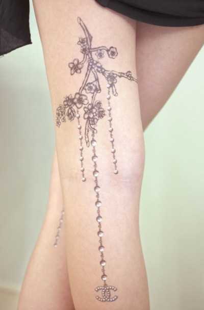 Tatuagem na perna da menina - um colar com pingente