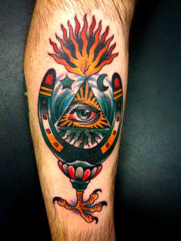 Tatuagem na perna de um cara - a pirâmide com o olho e a ferradura