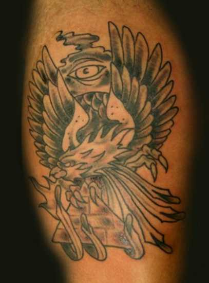 Tatuagem na perna de um cara - a pirâmide nas garras de águia e olho de