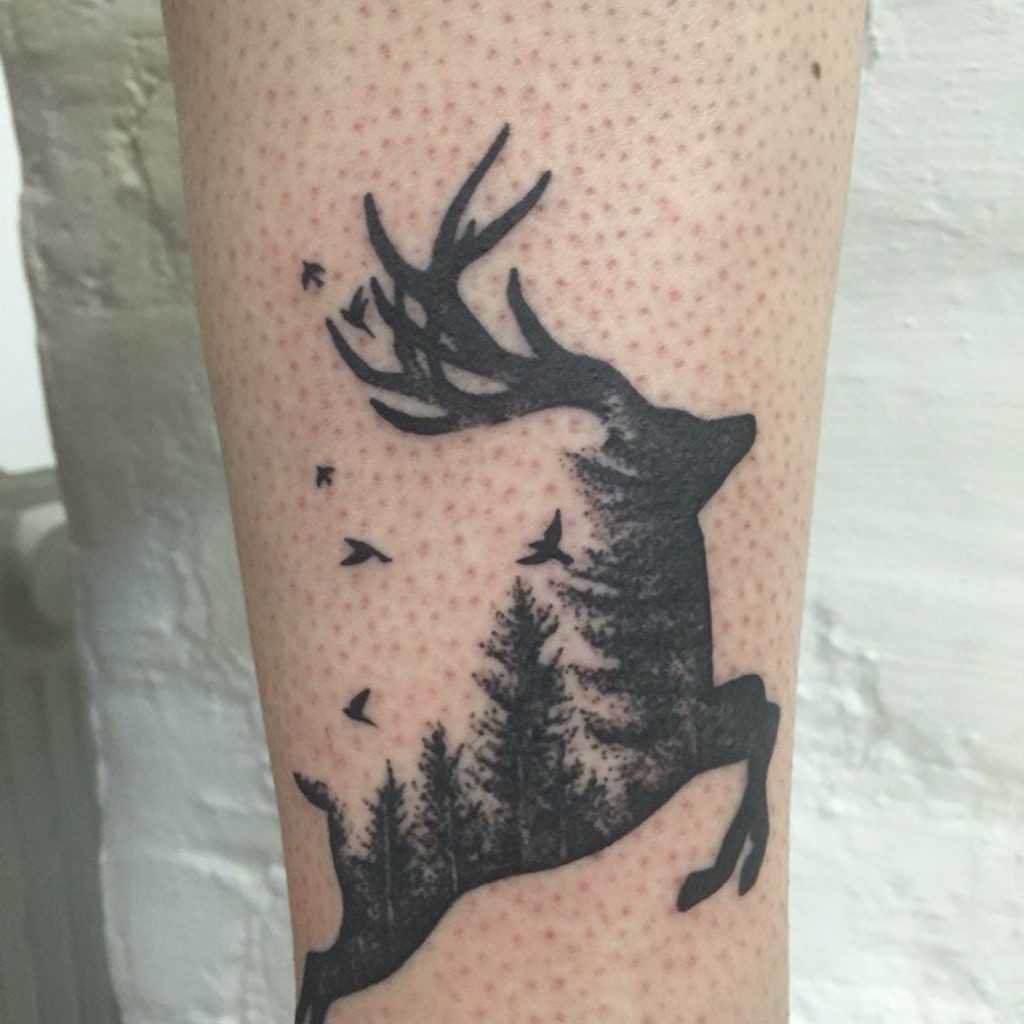 Tatuagem na perna de um cara - a silhueta de um cervo
