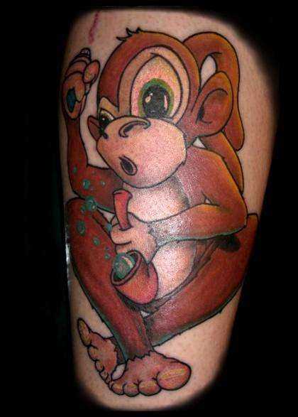 Tatuagem na perna de um cara - de- macaco, com um tubo de