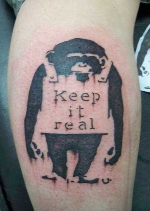 Tatuagem na perna de um cara de macaco e inscrição