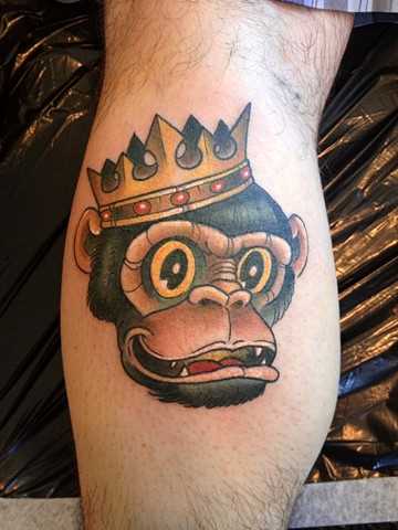 Tatuagem na perna de um cara de macaco na coroa