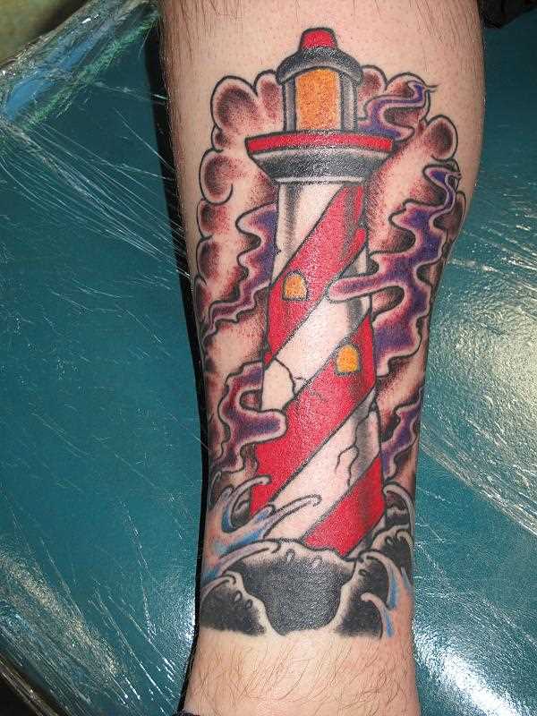 Tatuagem na perna de um cara em forma de farol