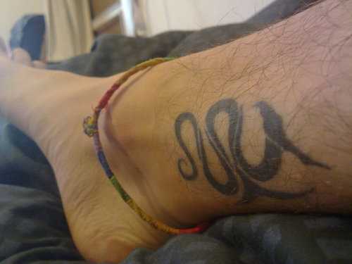 Tatuagem na perna de um cara em forma de serpente