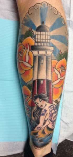 Tatuagem na perna de um cara - farol, de rosas e de sereia