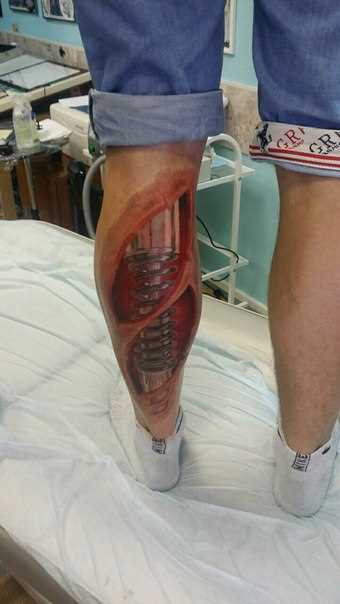Tatuagem na perna de um cara no estilo de biomecânica