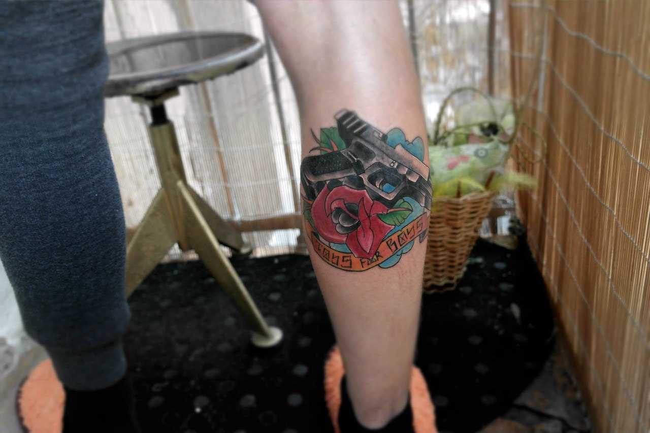 Tatuagem na perna do cara - a arma e rosa