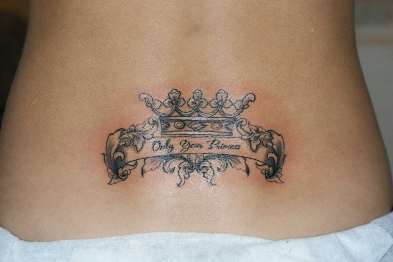 Tatuagem nas costas da menina - a coroa e a inscrição