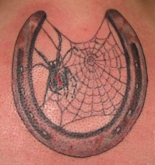 Tatuagem nas costas da menina - ferradura, homem-aranha e teia de aranha