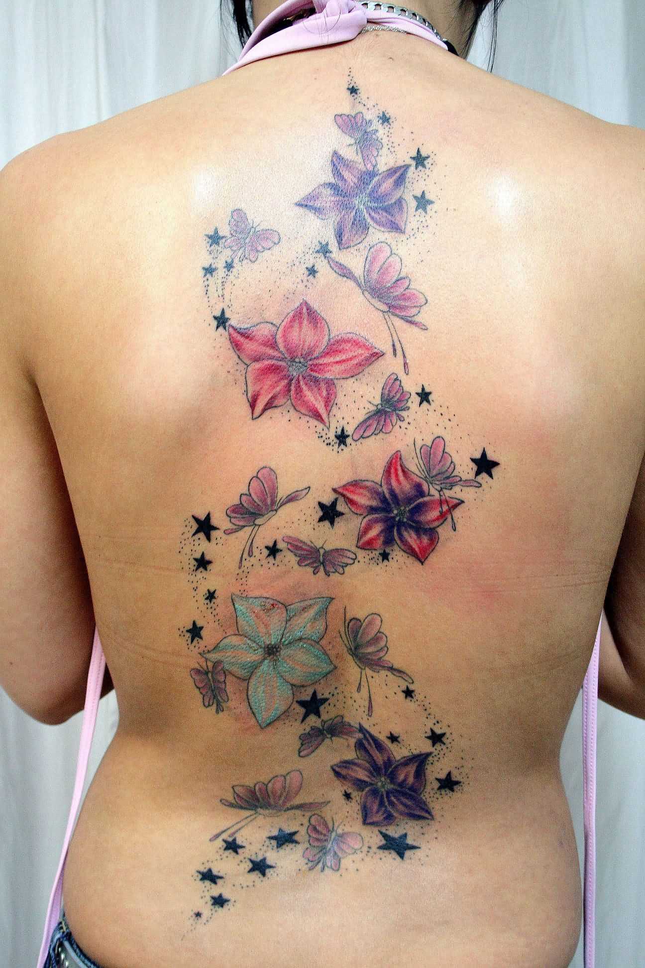 Tatuagem nas costas de uma menina - cores akvilegii e borboletas